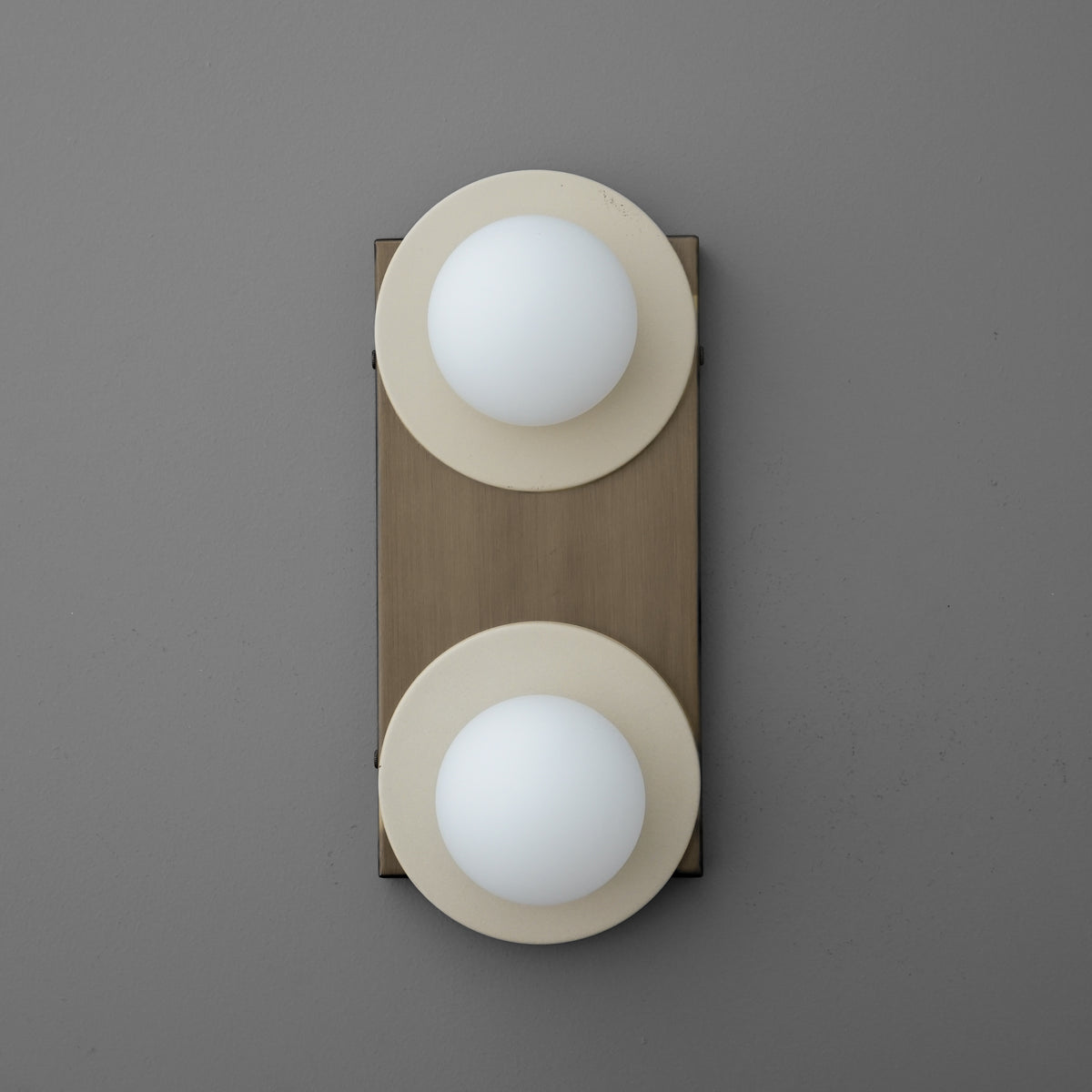 Two-light sconce with Cream round plates and opal glass globes on a tall rectangular Antique Brass backplate. - SCONCE MODEL NO. 8828