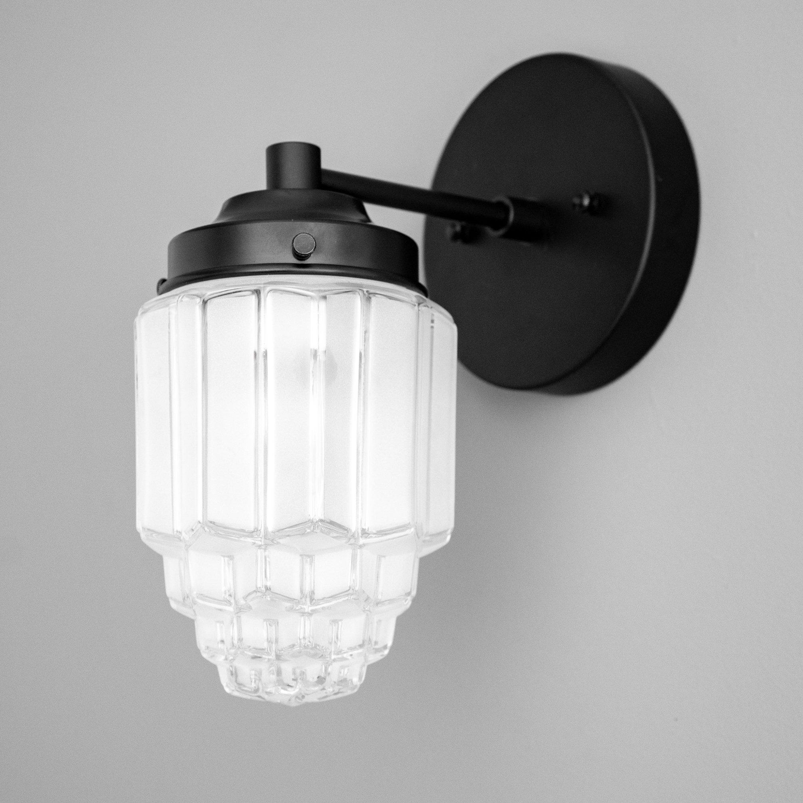 Art Deco black metal wall sconce with ribbed clear glass globe shade and round backplate. - SCONCE MODEL NO. 6130