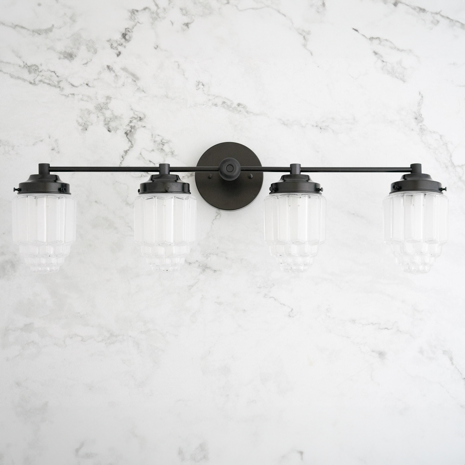 4-bulb black metal vanity light with frosted ribbed glass globe shades on marble wall. - VANITY LIGHT MODEL NO. 1082