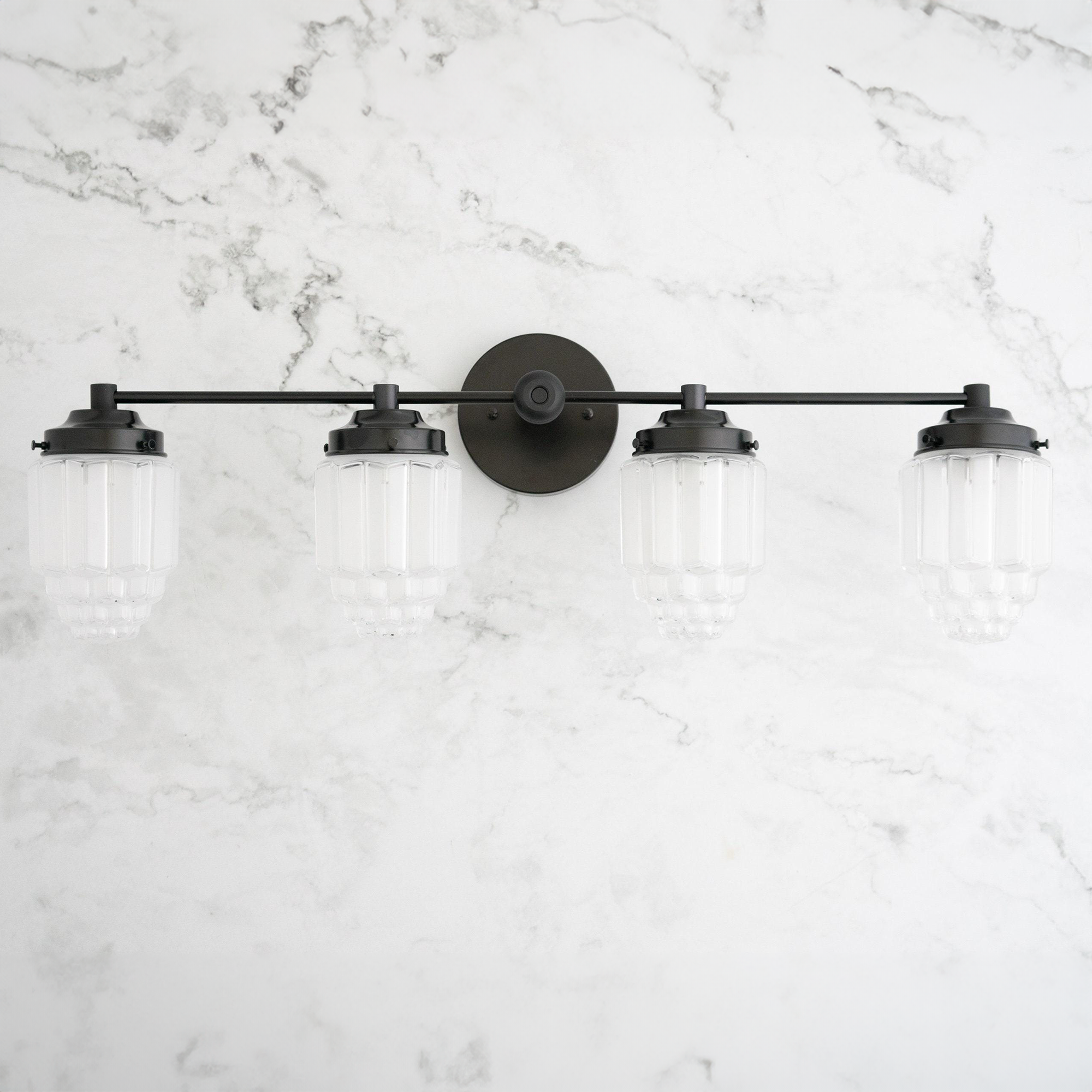 4-bulb black metal vanity light with frosted ribbed glass globe shades on marble wall. - VANITY LIGHT MODEL NO. 1082