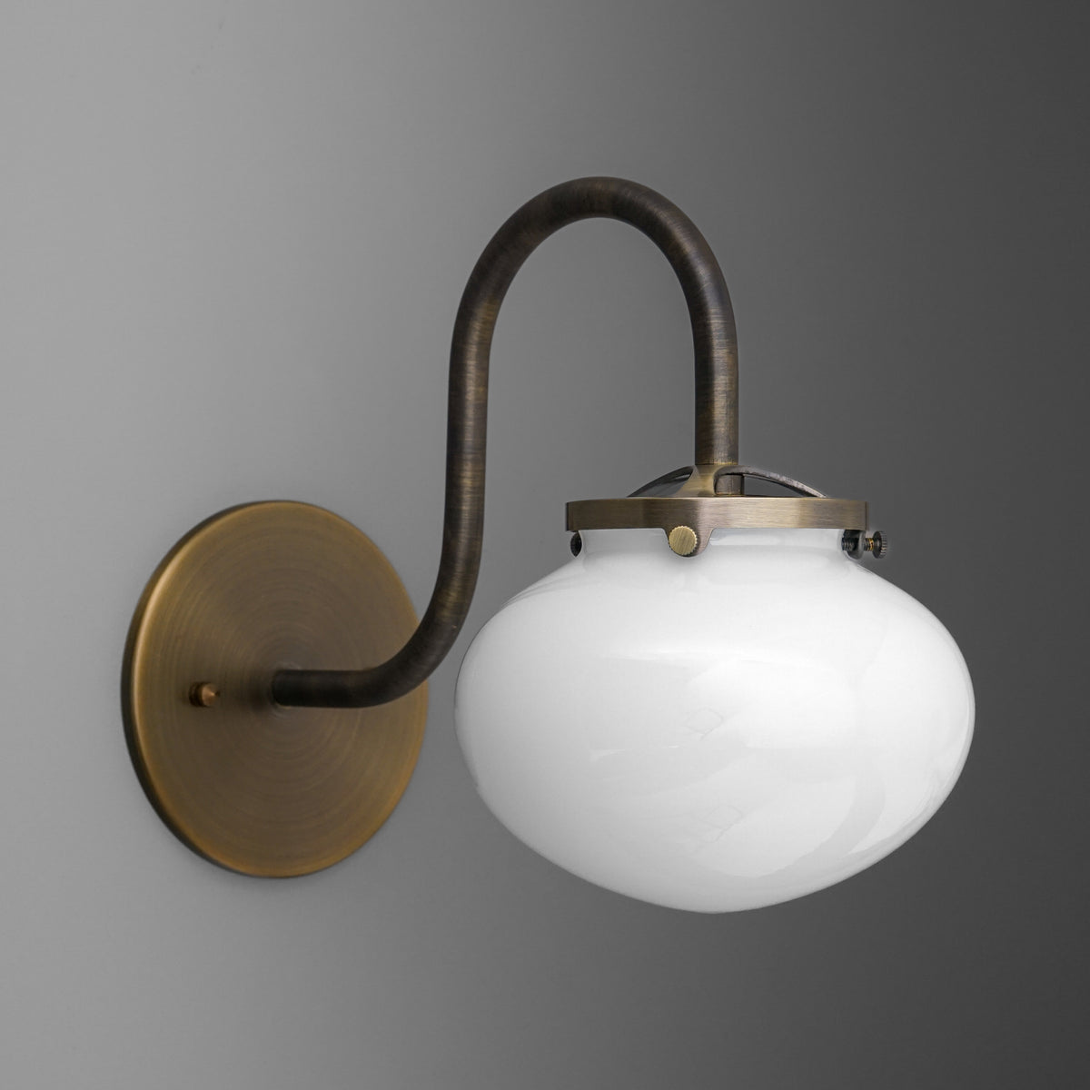 Antique brass wall sconce with curved arm and white glass globe shade. - SCONCE MODEL NO. 8563