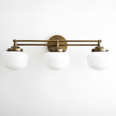 Three-bulb vanity light with raw brass finish and white globe shades in Art Deco style. - VANITY LIGHT MODEL NO. 4352
