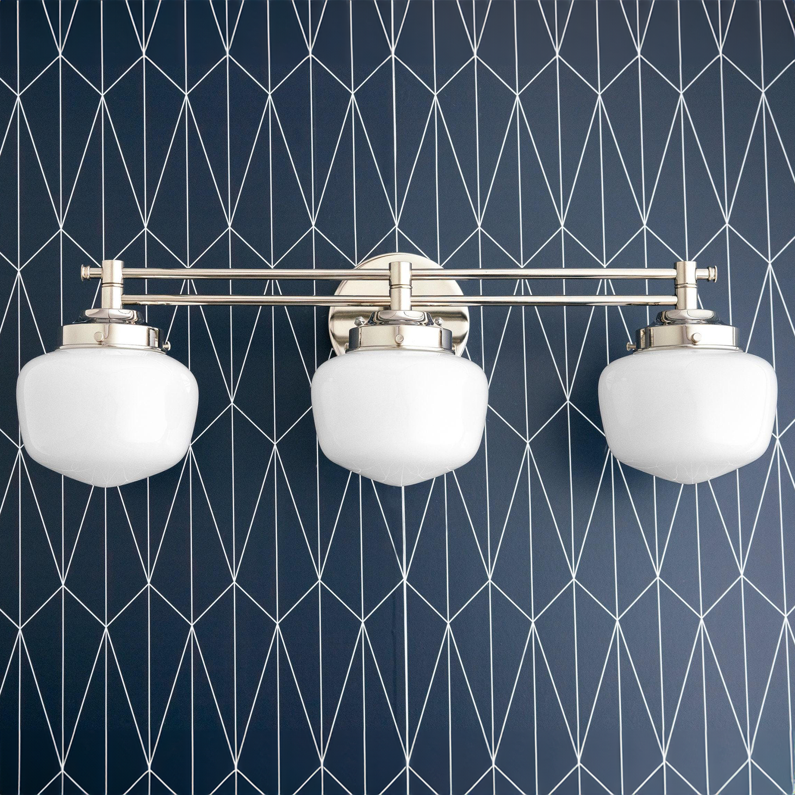 Three-globe vanity light in polished nickel with white opal glass shades mounted on a geometric navy blue wall. - VANITY LIGHT MODEL NO. 4352
