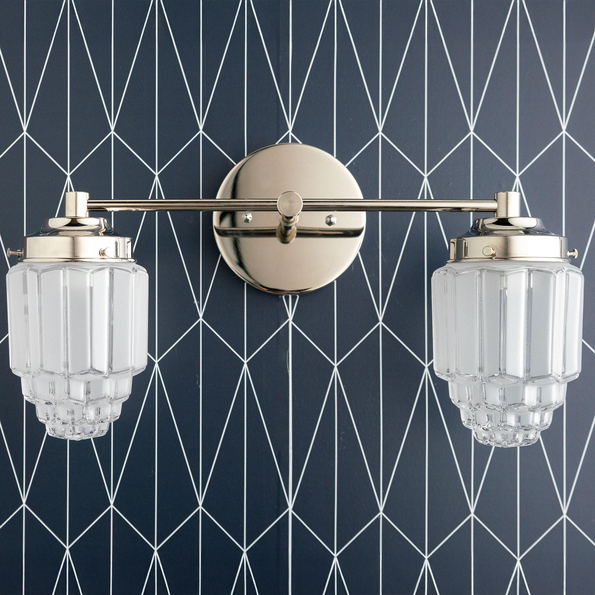 Polished nickel two-bulb vanity light with clear textured glass globes on geometric dark wall. - VANITY LIGHT MODEL NO. 9777