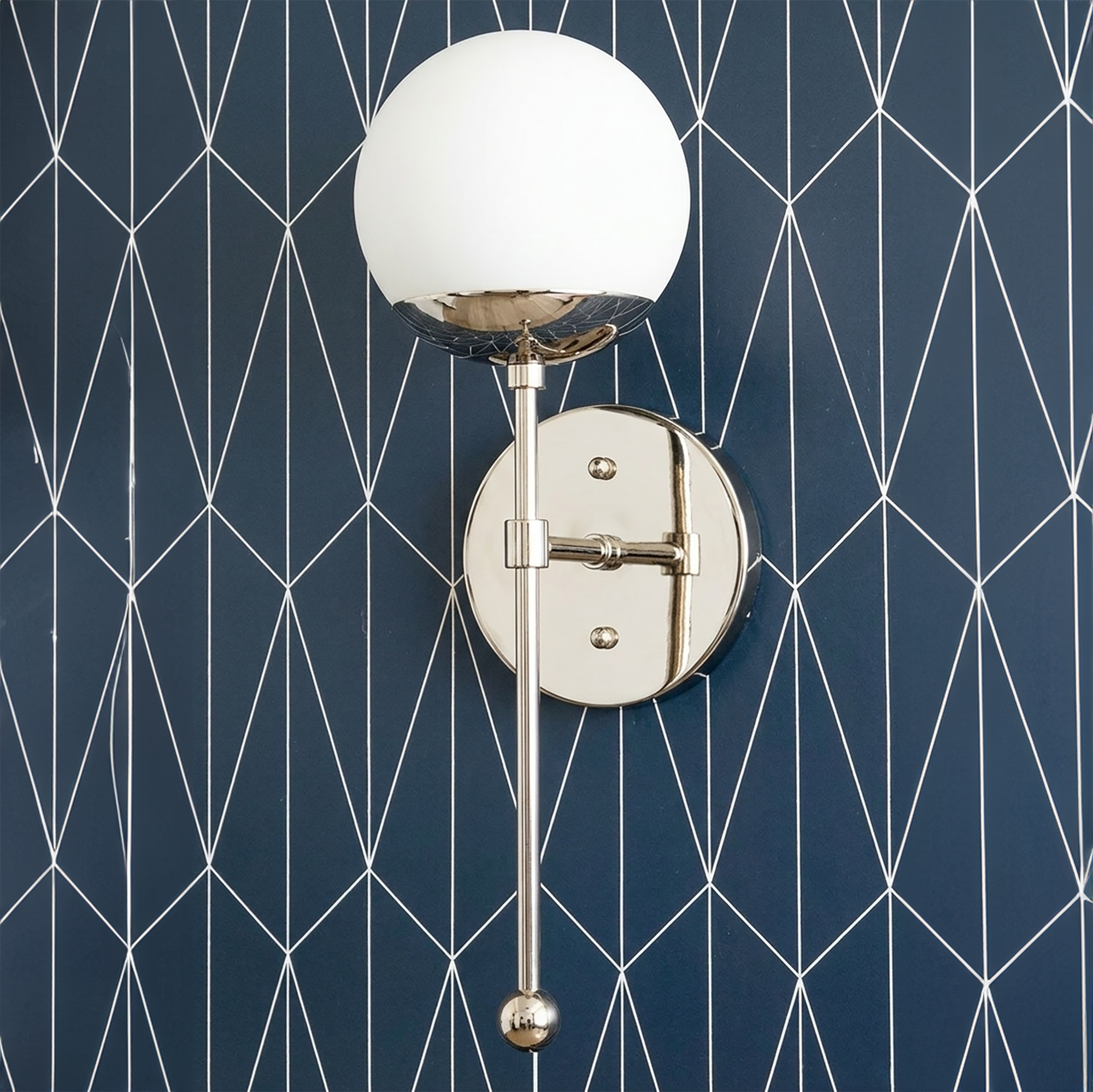Brushed nickel Art Deco sconce with white glass globe and adjustable arm mounted on geometric navy wall. - SCONCE MODEL NO. 1048