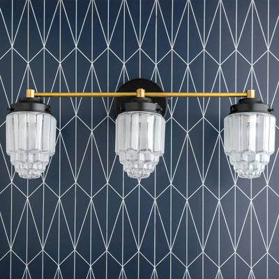 Three-bulb vanity light with tiered glass globes and a horizontal brass bar mounted on black fixtures. - VANITY LIGHT MODEL NO. 3918