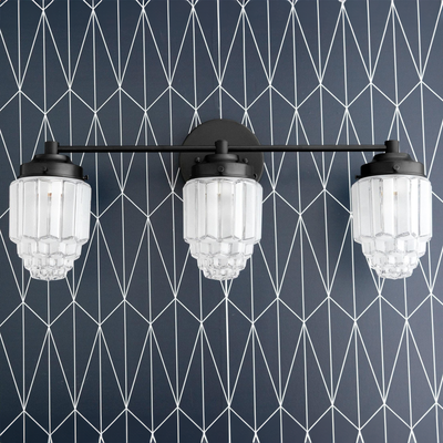 Black metal vanity light with three tiered globe glass shades against geometric wallpaper. - VANITY LIGHT MODEL NO. 3918