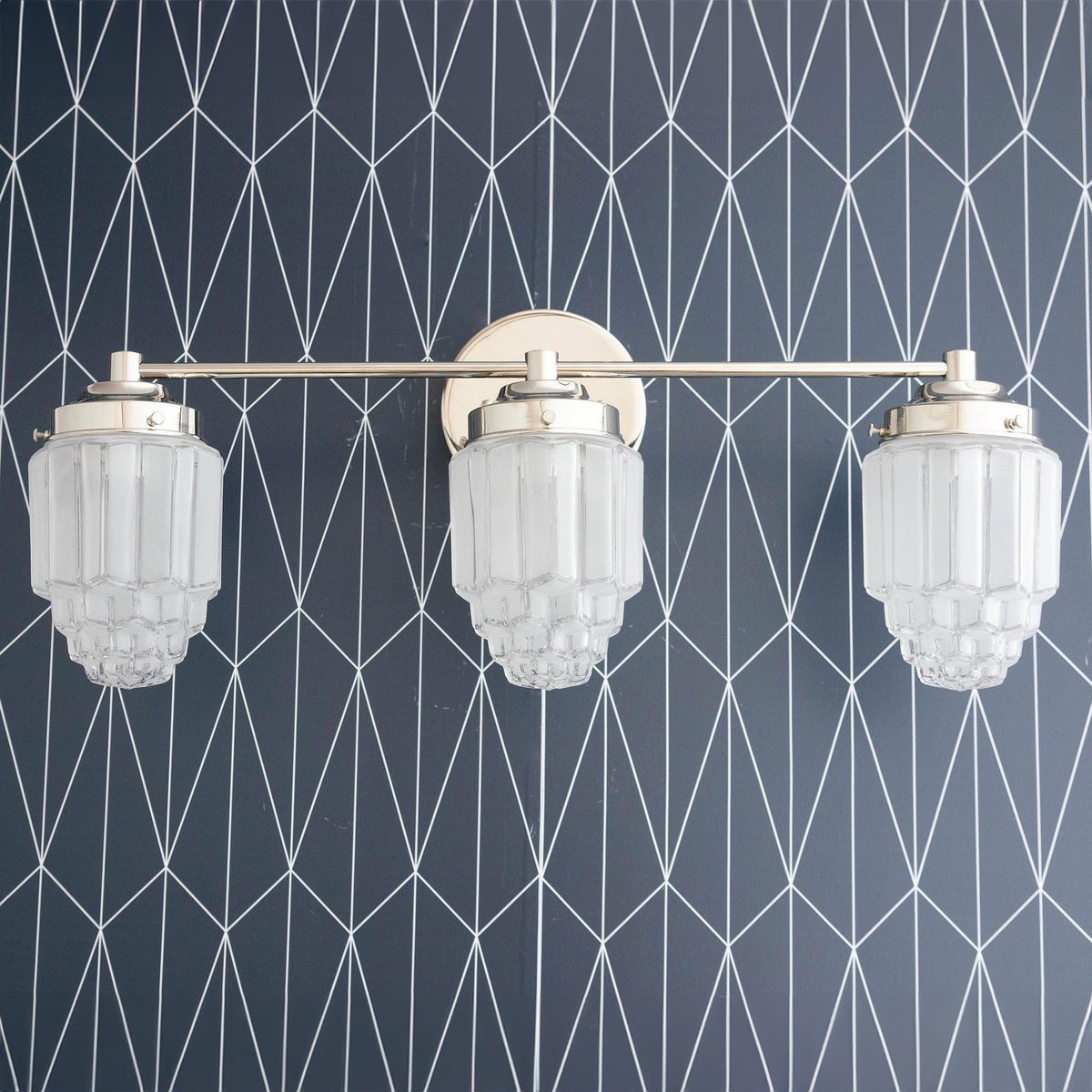 Three-bulb vanity light with polished nickel finish and textured glass globe shades against geometric wallpaper. - VANITY LIGHT MODEL NO. 3918