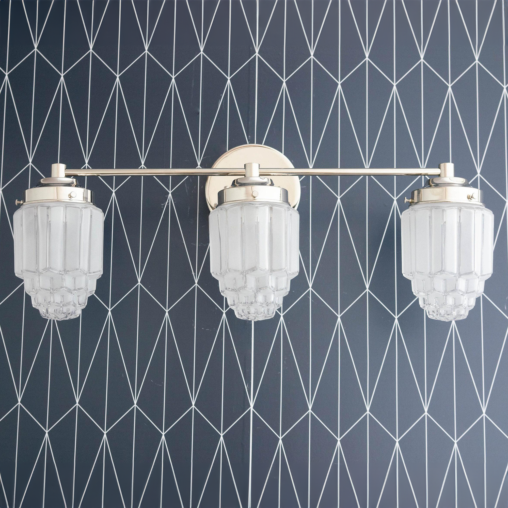 Three-bulb vanity light with polished nickel finish and textured glass globe shades against geometric wallpaper. - VANITY LIGHT MODEL NO. 3918