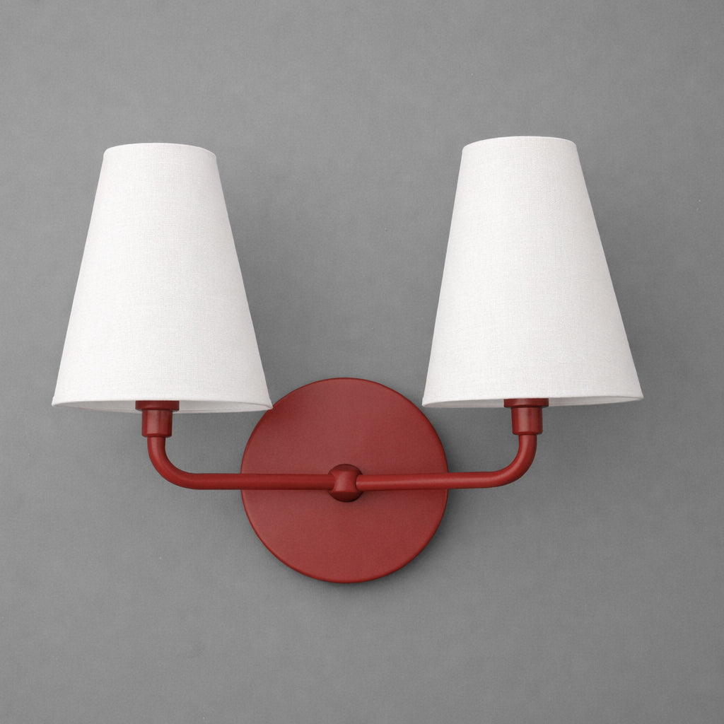 Red metal double-arm wall sconce with round base and white tapered fabric shades. - SCONCE MODEL NO. 1315