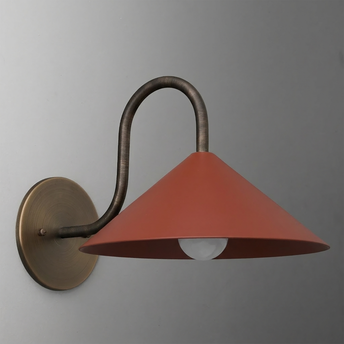 Wall-mounted sconce with a curved bronze arm and wide matte terracotta conical shade above a single bulb. - SCONCE MODEL NO. 1015