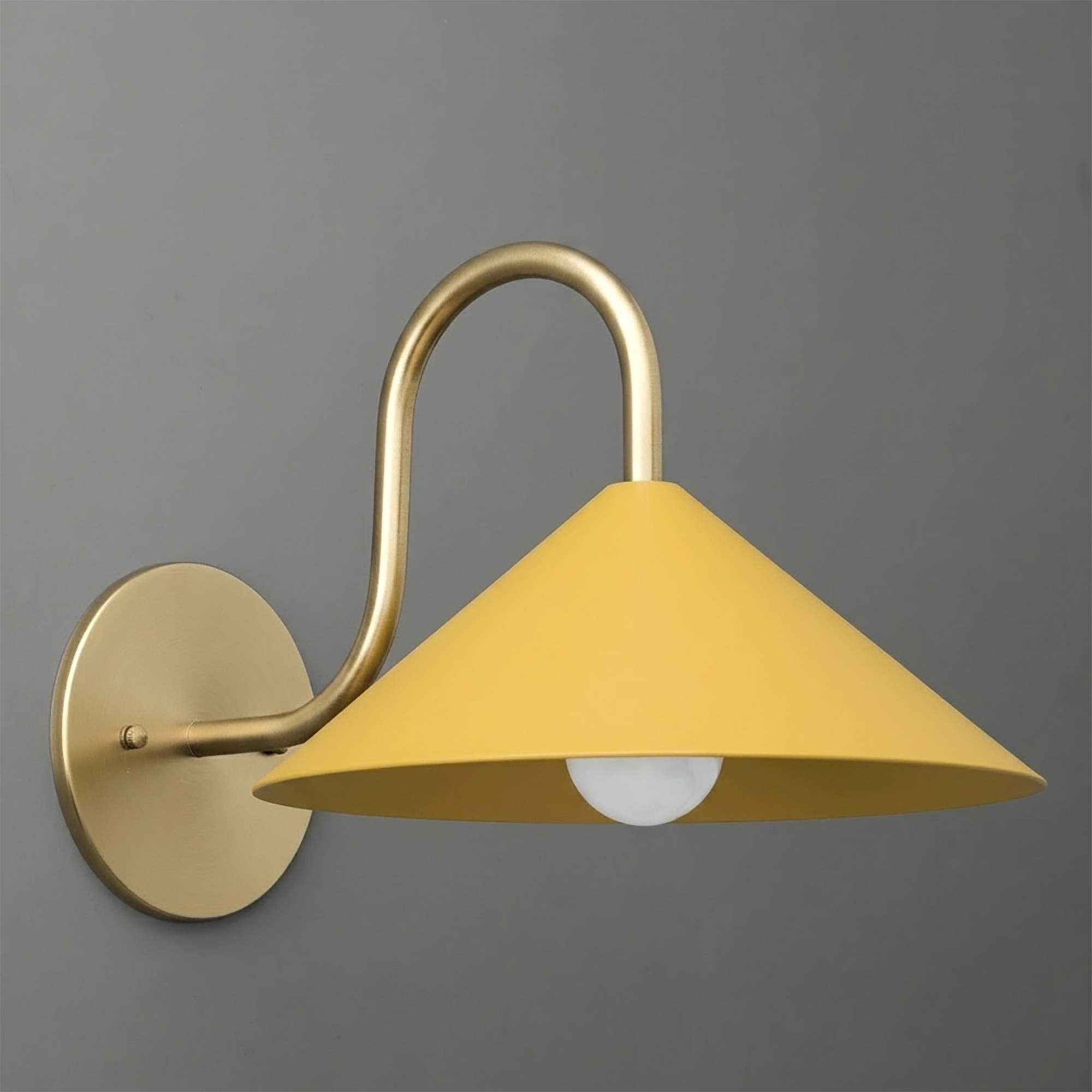 Matte yellow metal cone shade with curved brass arm and round brass wall plate sconce with one bulb. - SCONCE MODEL NO. 1015
