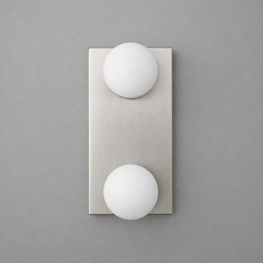 Brushed nickel rectangular wall sconce with two round white glass globe bulbs arranged vertically. - SCONCE MODEL NO. 4016