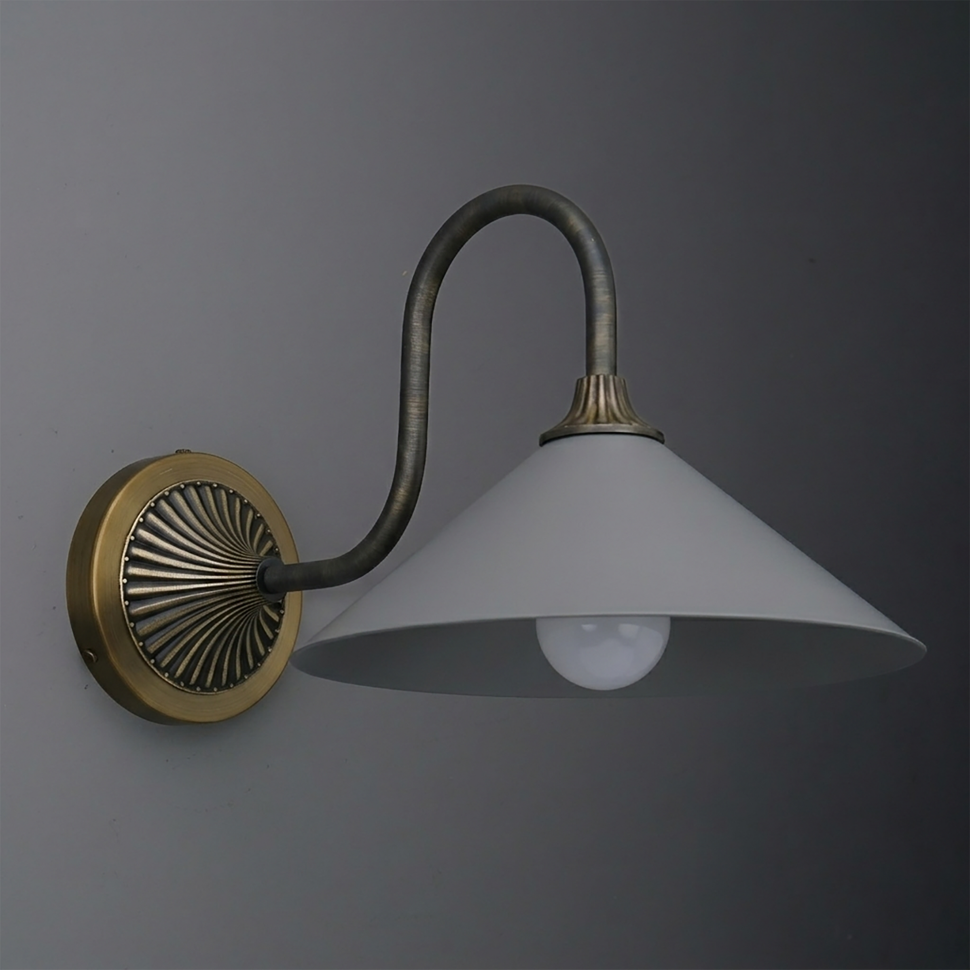 Wall sconce with aged brass circular base, curved dark metal arm, and wide white conical shade. - SCONCE MODEL NO. 1031