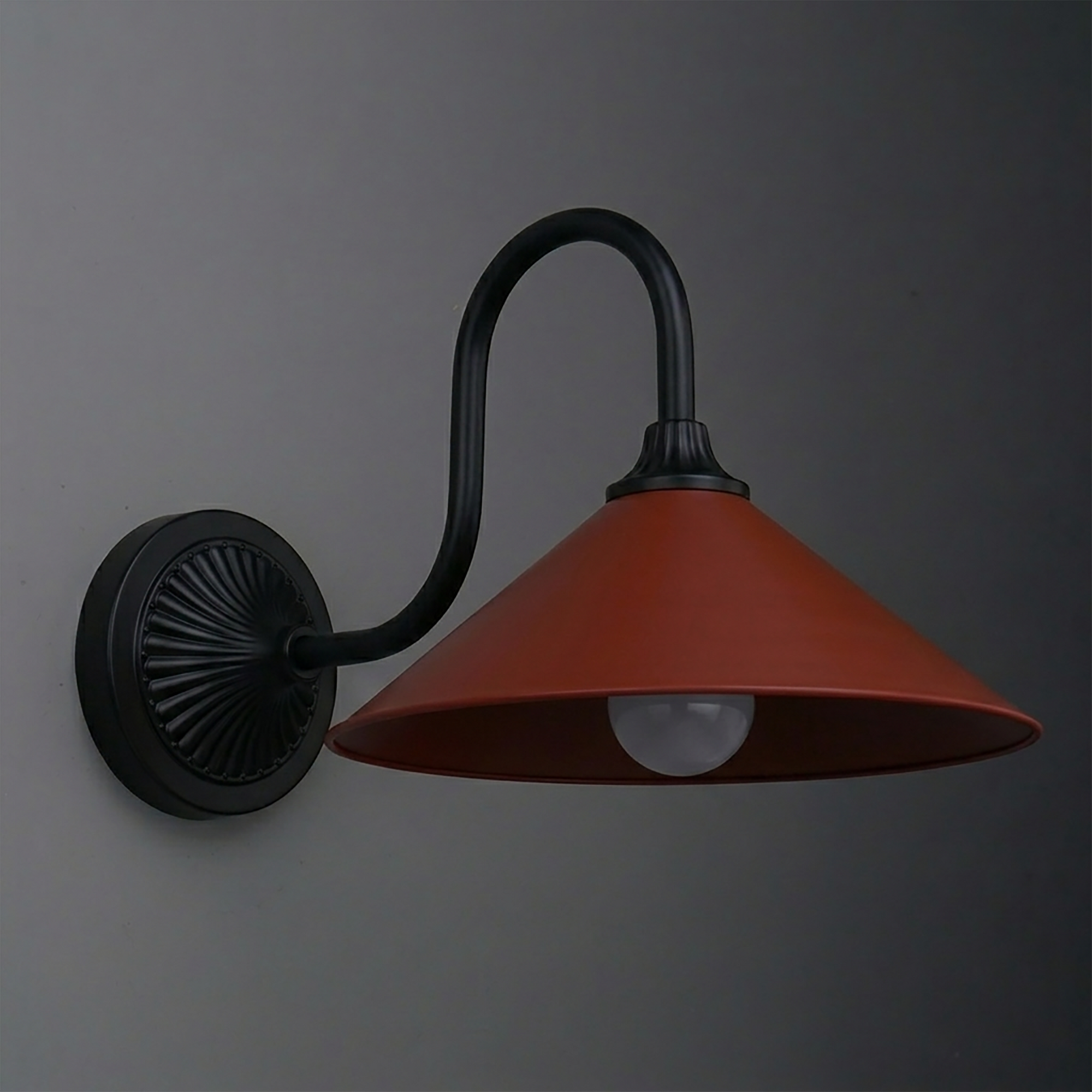 Black metal wall sconce with curved arm and wide conical rust-colored shade housing a single bulb. - SCONCE MODEL NO. 1031