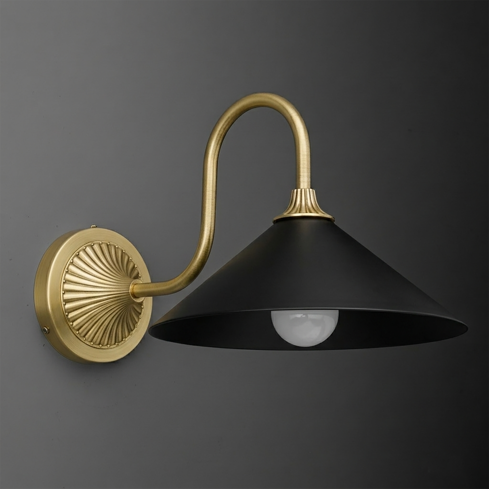 Wall sconce with matte black conical shade and curved brushed brass arm attached to round decorative brass mounting plate. - SCONCE MODEL NO. 1031