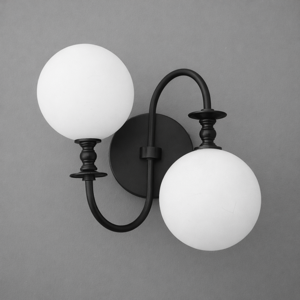 Black metal double-arm wall sconce with two matte white globe glass shades. - SCONCE MODEL NO. 2429
