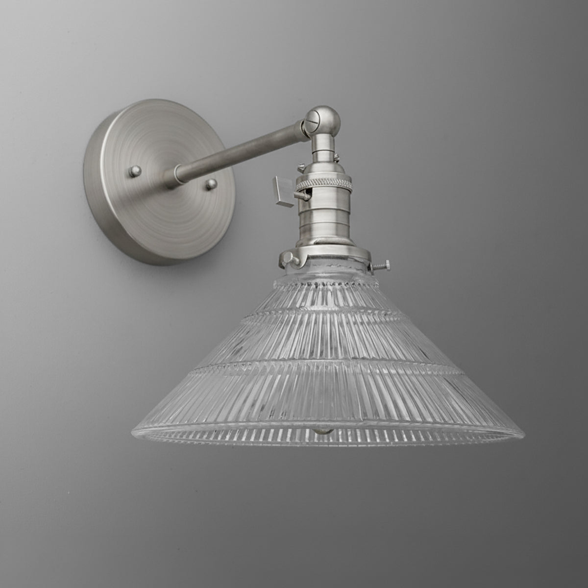 Wall sconce with brushed metal round base and extended arm, conical ribbed glass shade. - SCONCE MODEL NO. 3170
