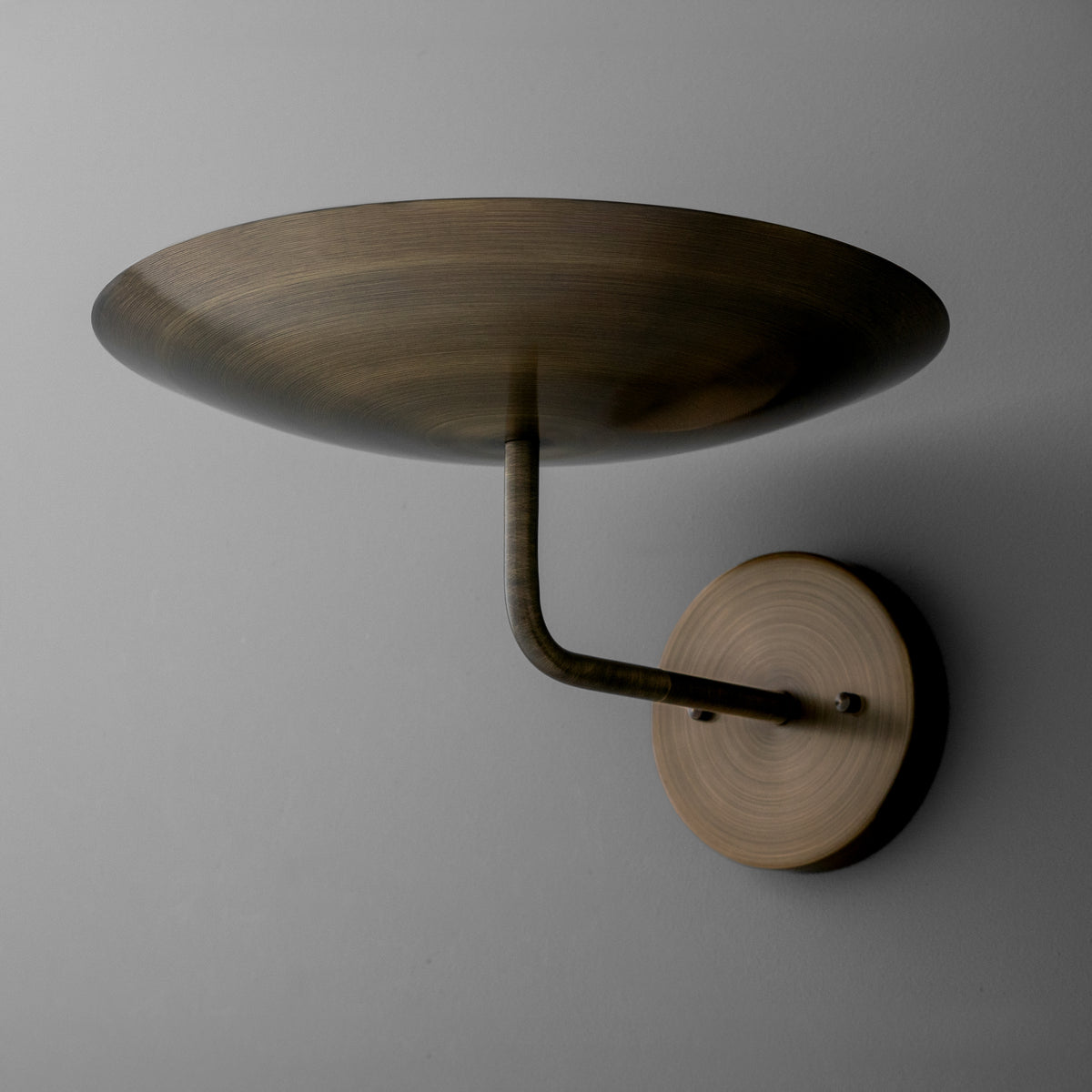 Wall sconce with a round wooden base and curved metal arm supporting a wide, shallow, bronze-finished metal shade. - SCONCE MODEL NO. 1504