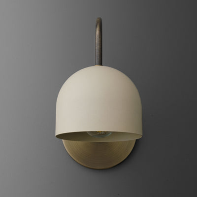 Antique brass sconce with smooth cream dome shade and curved arm on gray background. - SCONCE MODEL NO. 6308