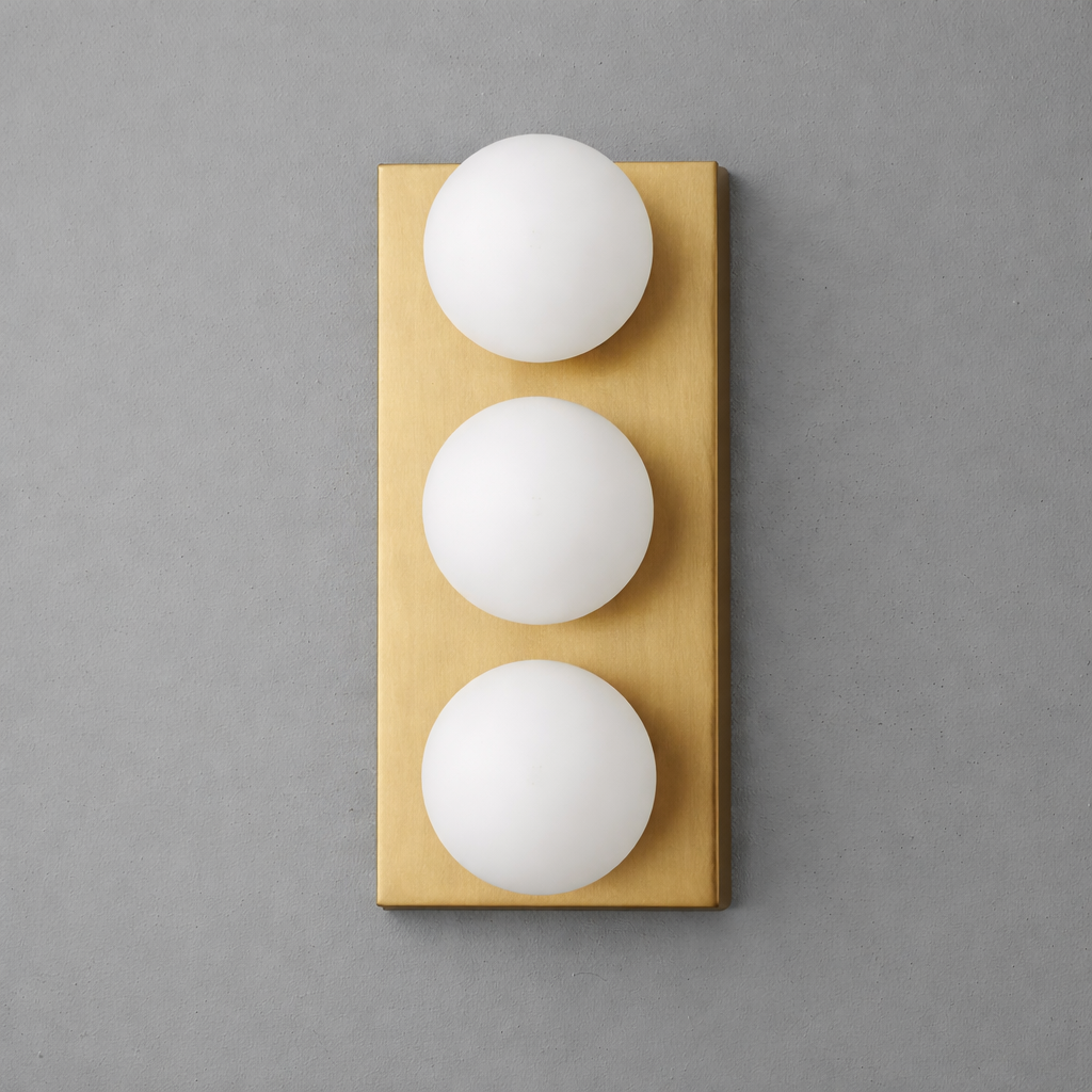 Modern wall sconce with three round white glass globes mounted on a vertical brushed brass rectangular base. - SCONCE MODEL NO. 2623