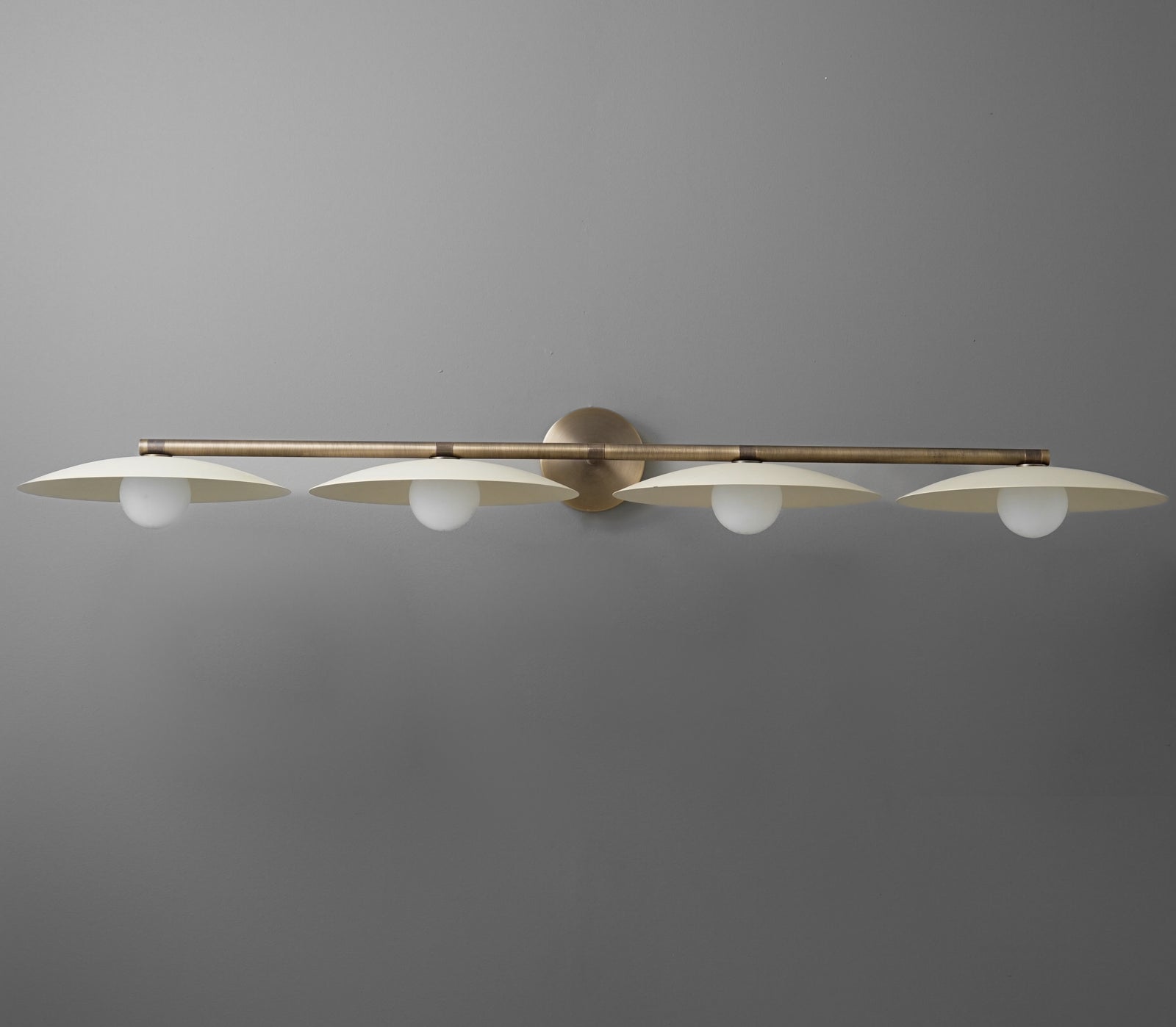 Brushed brass vanity light fixture with four evenly spaced white glass globe bulbs and a slim horizontal bar design. - VANITY LIGHT MODEL NO. 1152