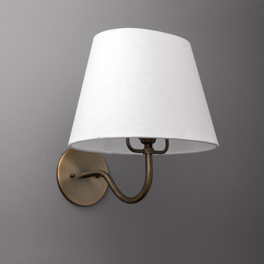 Wall sconce with antique brass finish and white tapered fabric shade against gray background. - SCONCE MODEL NO. 0303