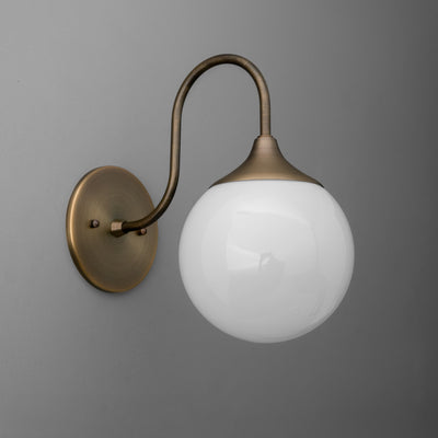 Wall sconce with antique brass curved arm and round white frosted glass globe shade. - SCONCE MODEL NO. 3961