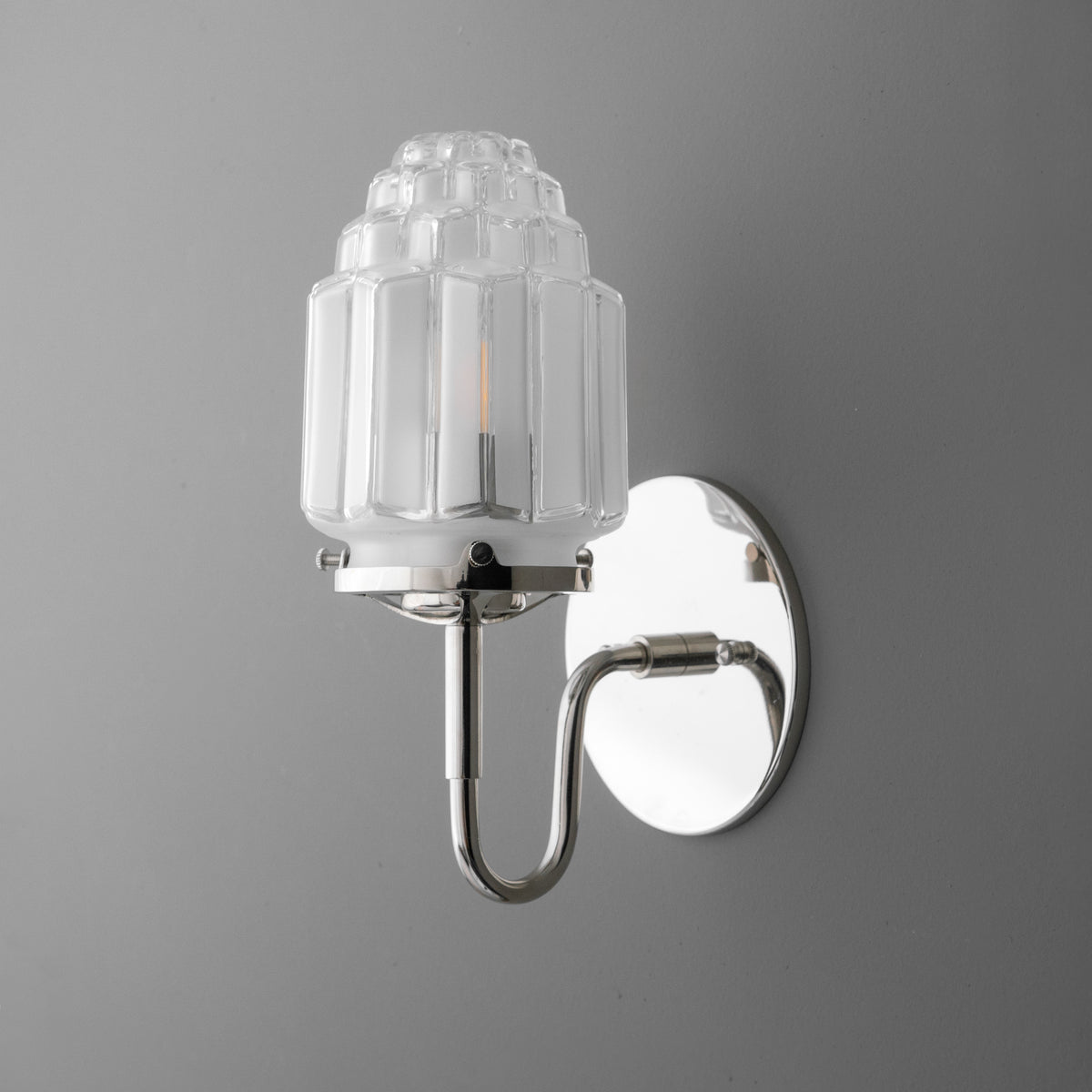 Chrome single-bulb wall sconce with ribbed glass shade and oval backplate. - SCONCE MODEL NO. 1035