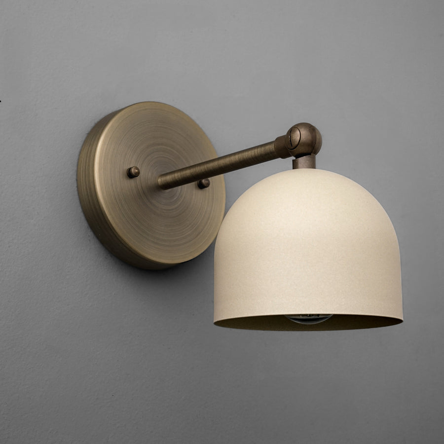 Antique brass wall sconce with a smooth cream dome-shaped shade and round backplate. - SCONCE MODEL NO. 5103