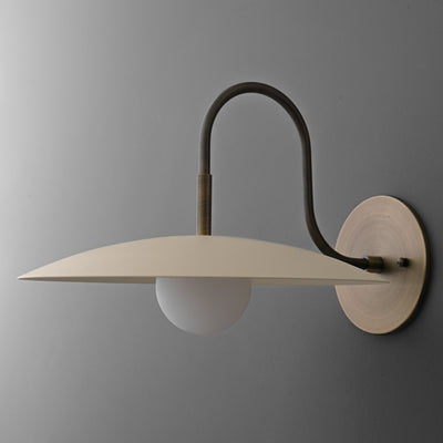 Wall sconce with matte cream disc shade and curved antique brass arm mounted on round base. - SCONCE MODEL NO. 9171