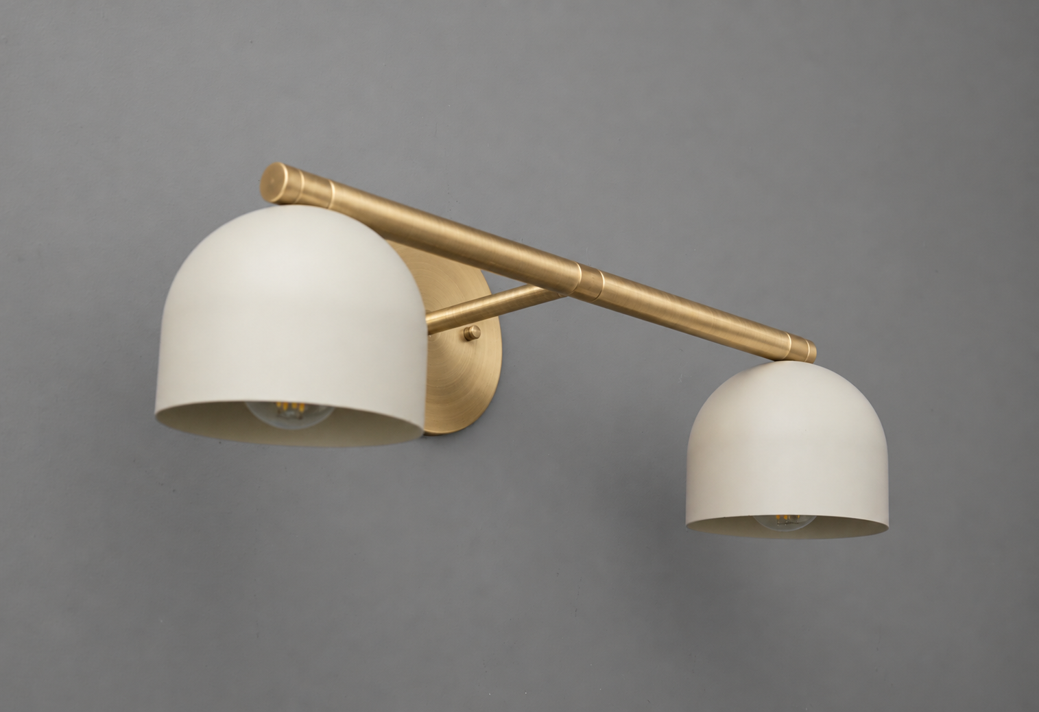 Side angle of the vanity light in Raw or Sealed Brass with Cream steel dome shades, showing the bulbs and the round wall plate. - VANITY LIGHT MODEL NO. 1186