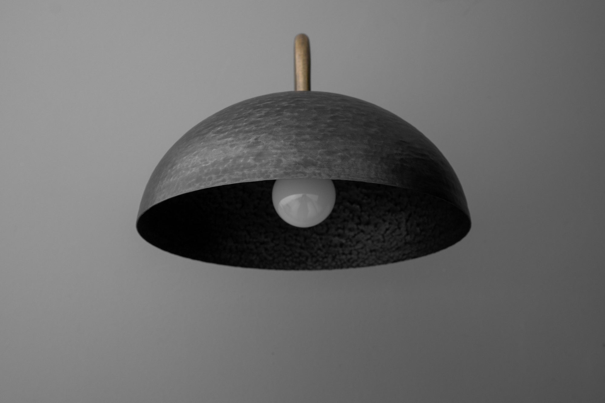 Minimalist dome-shaped black metal sconce with exposed bulb and brass stem mounting. - SCONCE MODEL NO. 9874