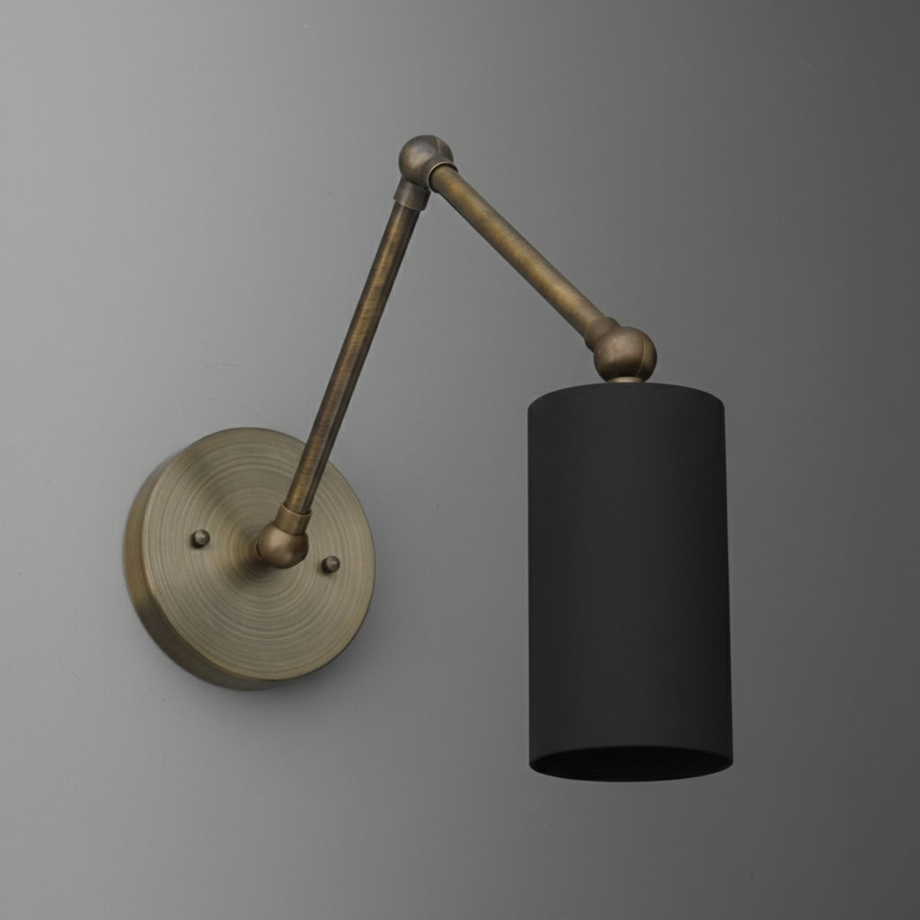 Wall-mounted adjustable brass arm sconce with a cylindrical black metal shade and round base. - SCONCE MODEL NO. 0357