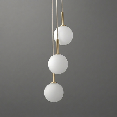 Modern chandelier with three white matte glass globes suspended vertically on slim brushed brass rods against a gray. - CHANDELIER MODEL NO. 4701