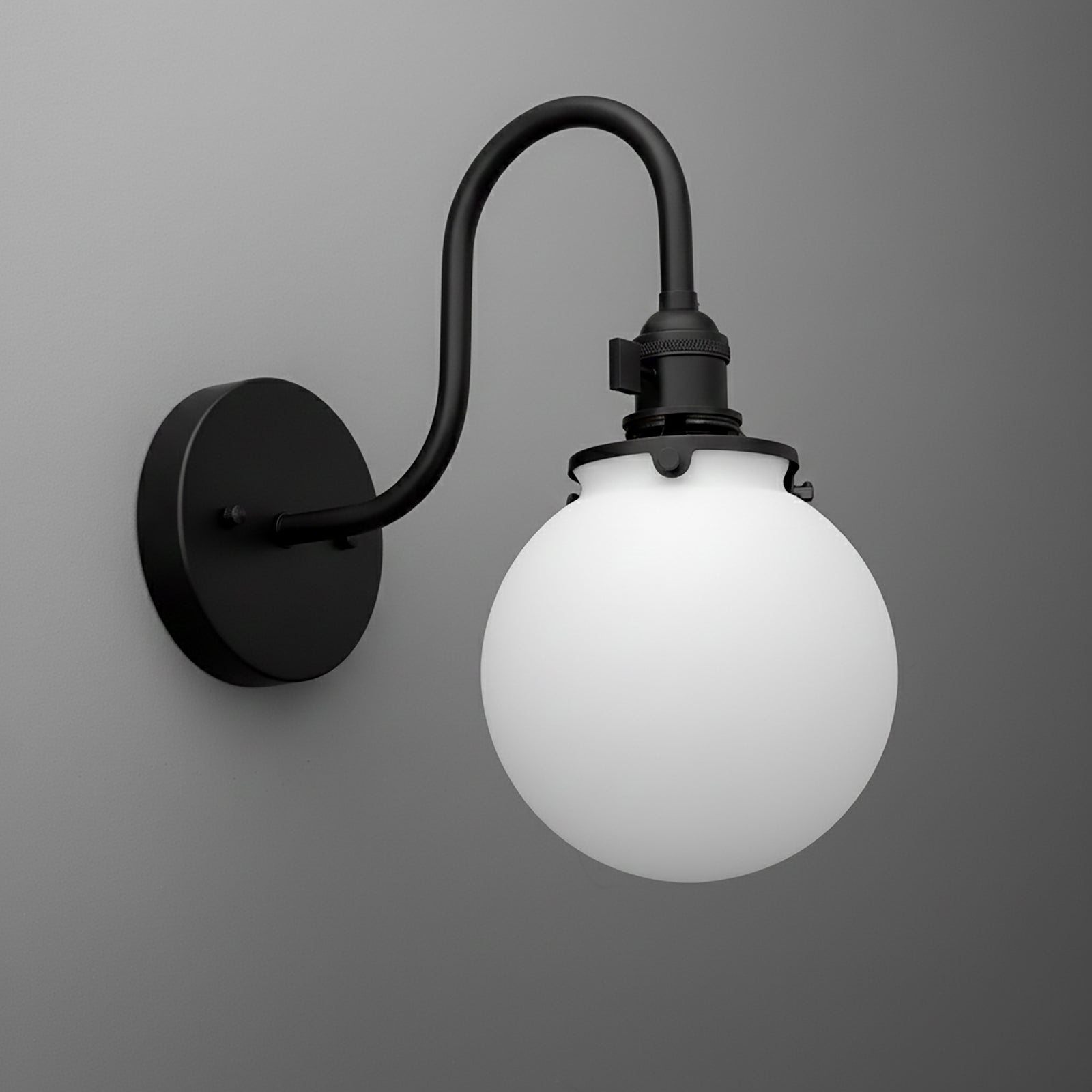 Matte black metal wall sconce with curved arm and frosted white glass globe shade. - SCONCE MODEL NO. 0017