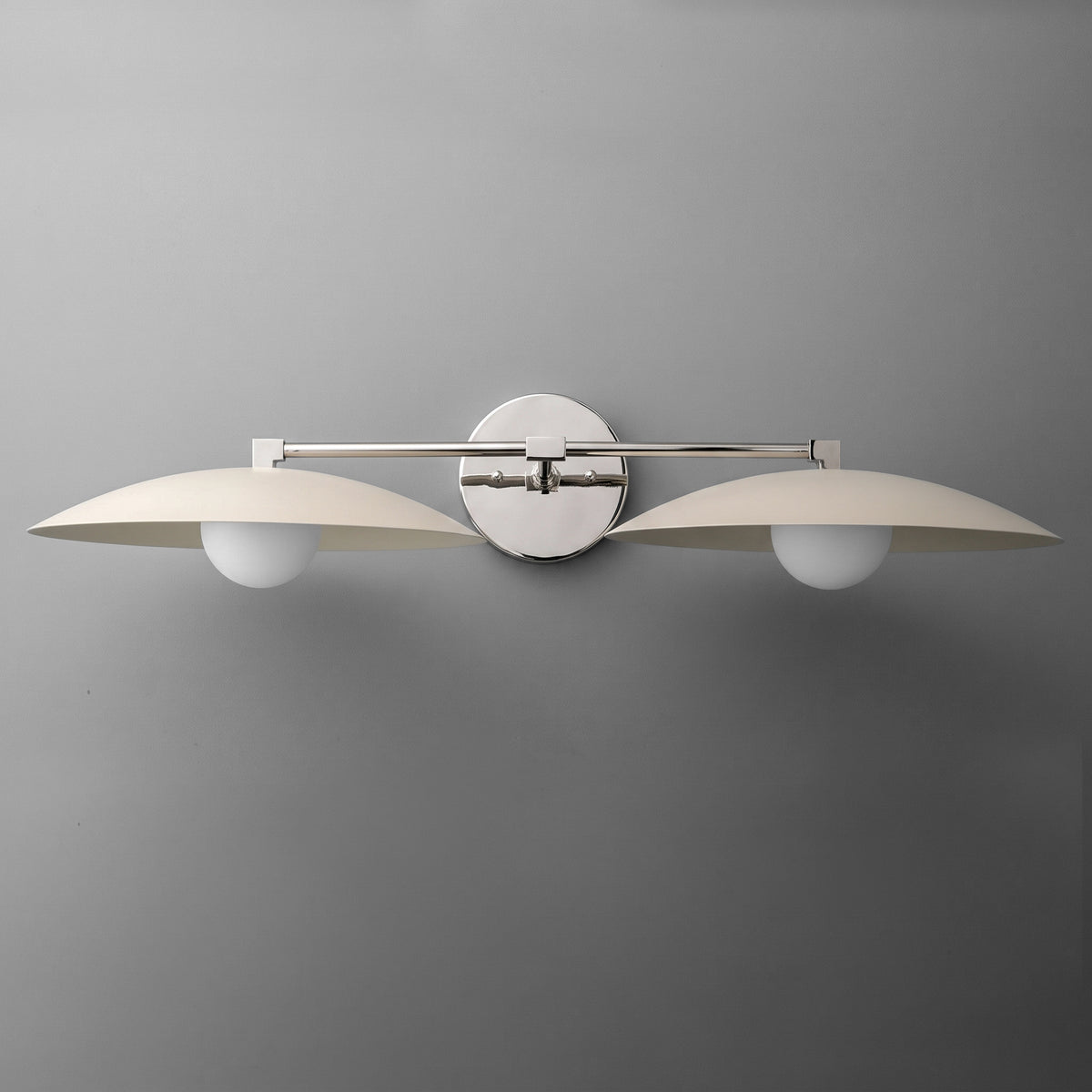 Two-bulb vanity light with brushed metal finish and curved white shades mounted on round wall plate. - VANITY LIGHT MODEL NO. 1168