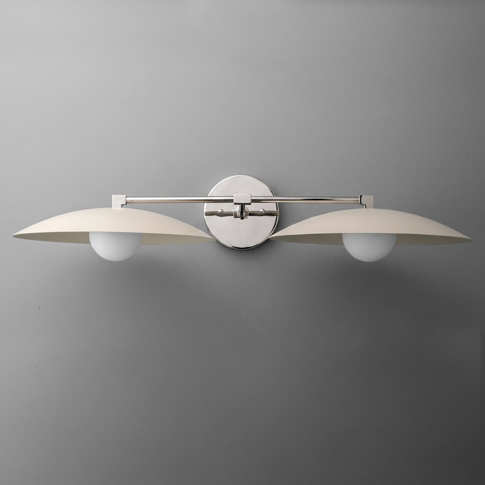 Two-bulb vanity light with brushed metal finish and curved white shades mounted on round wall plate. - VANITY LIGHT MODEL NO. 1168