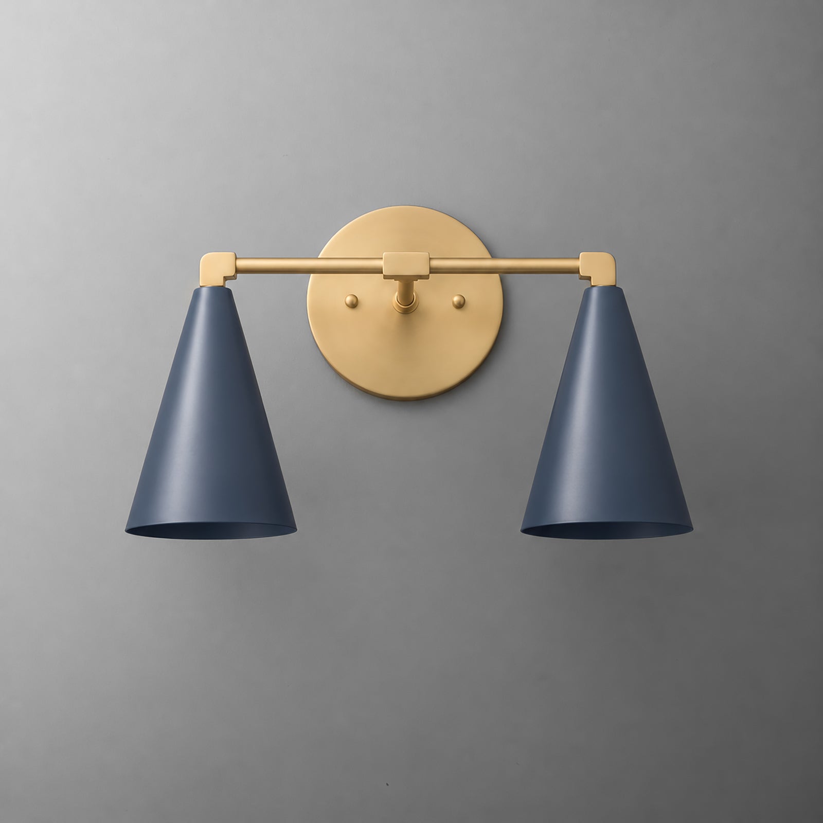 Two-light vanity light in Raw or Sealed Brass with Coal Blue cone shades on a straight arm and a round wall plate. - VANITY LIGHT MODEL NO. 1184