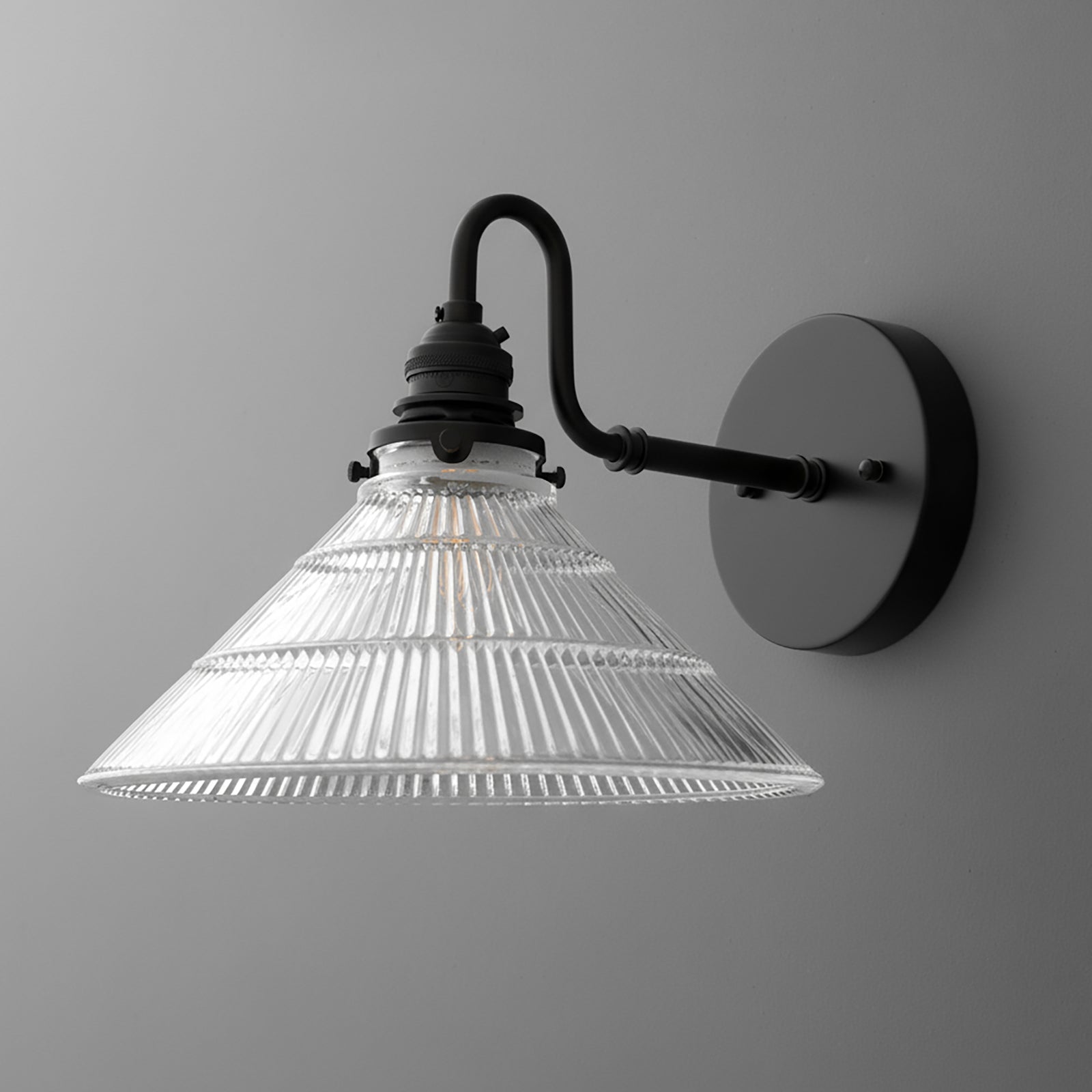 Matte black metal wall sconce with a clear ribbed glass conical shade and curved arm design. - SCONCE MODEL NO. 4703