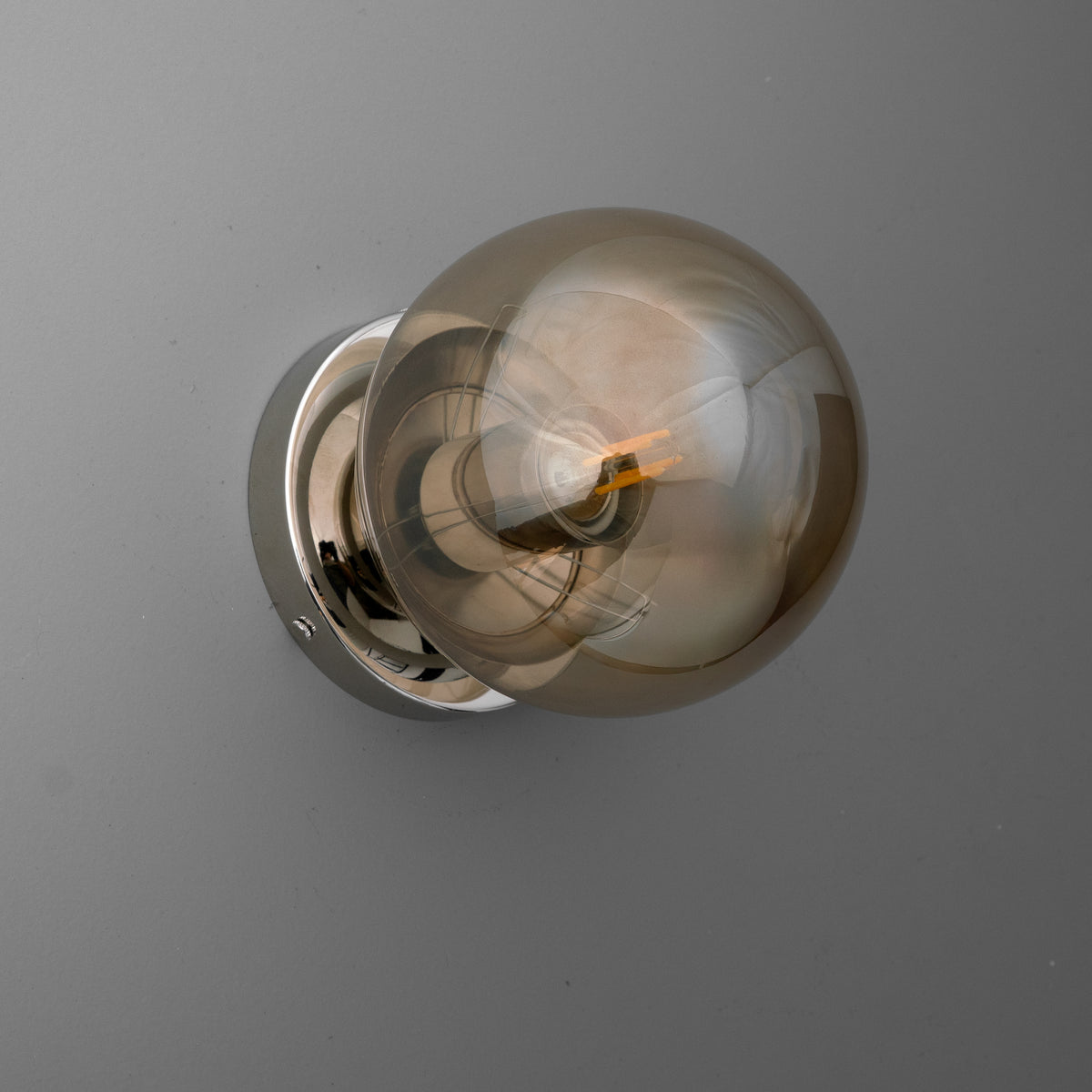 Modern wall sconce with a round chrome base and a large smoked glass globe bulb. - SCONCE MODEL NO. 1030