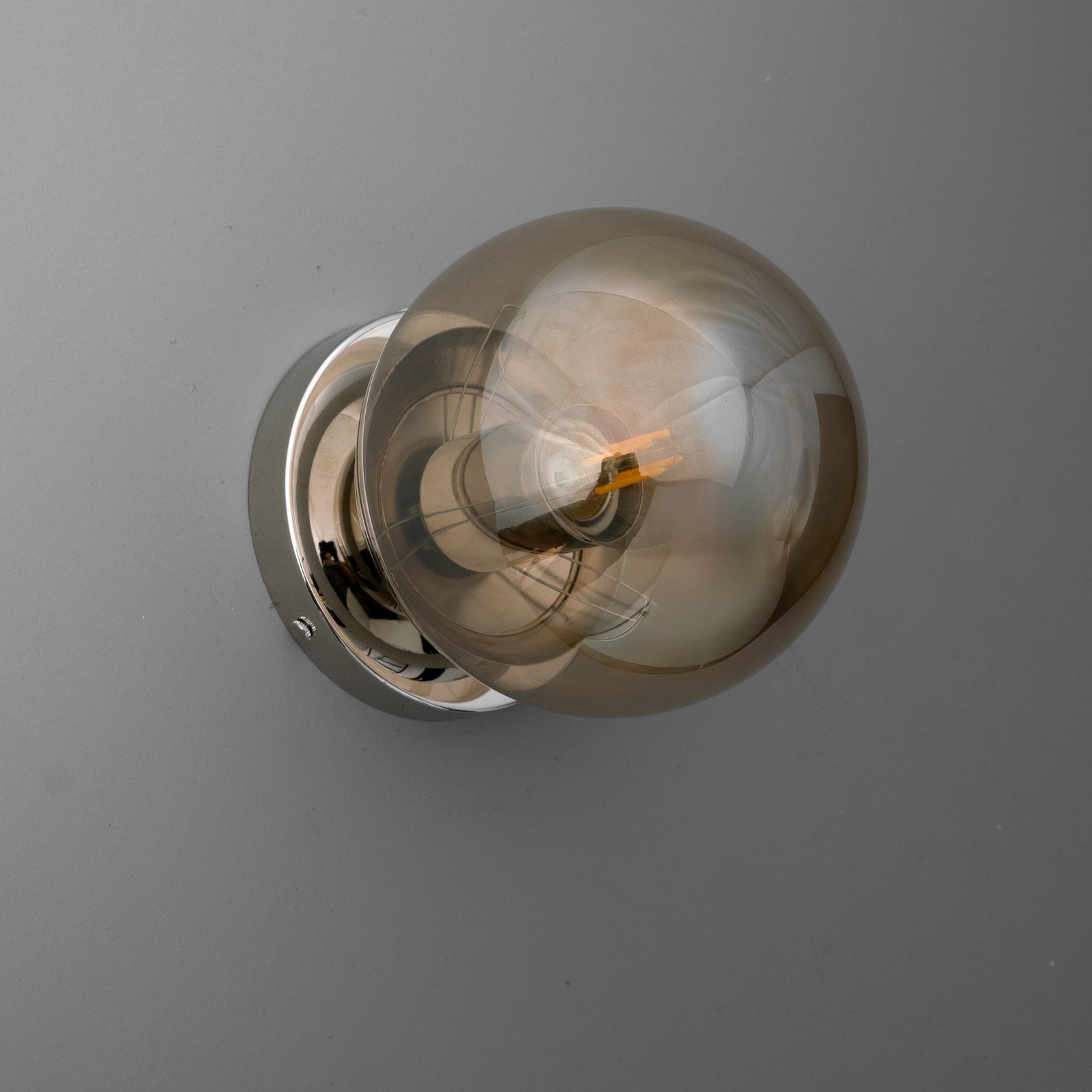 Modern wall sconce with a round chrome base and a large smoked glass globe bulb. - SCONCE MODEL NO. 1030