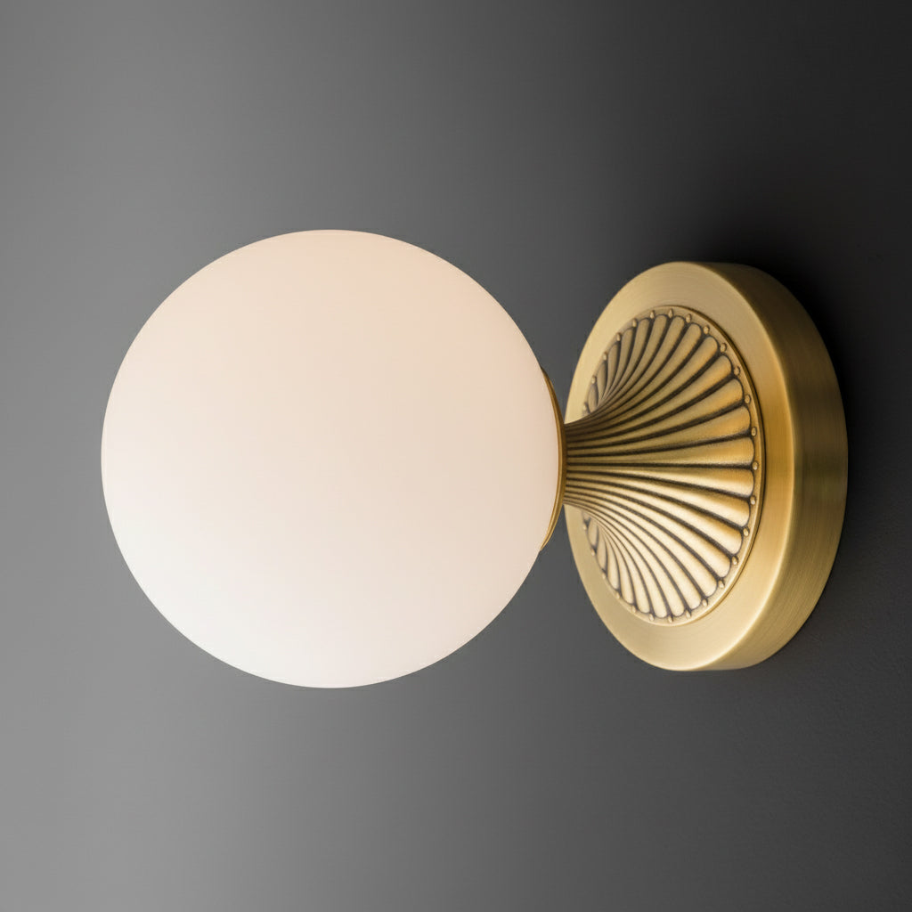 Wall sconce with round white glass globe and antique brass radial patterned metal base. - SCONCE MODEL NO. 5363