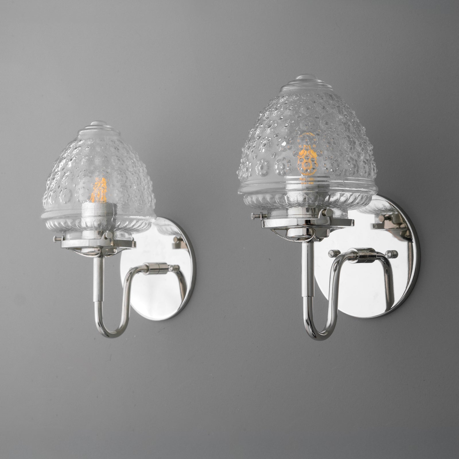 Wall sconce with polished chrome base and clear textured glass globe shade enclosing a single bulb. - SCONCE MODEL NO. 1037