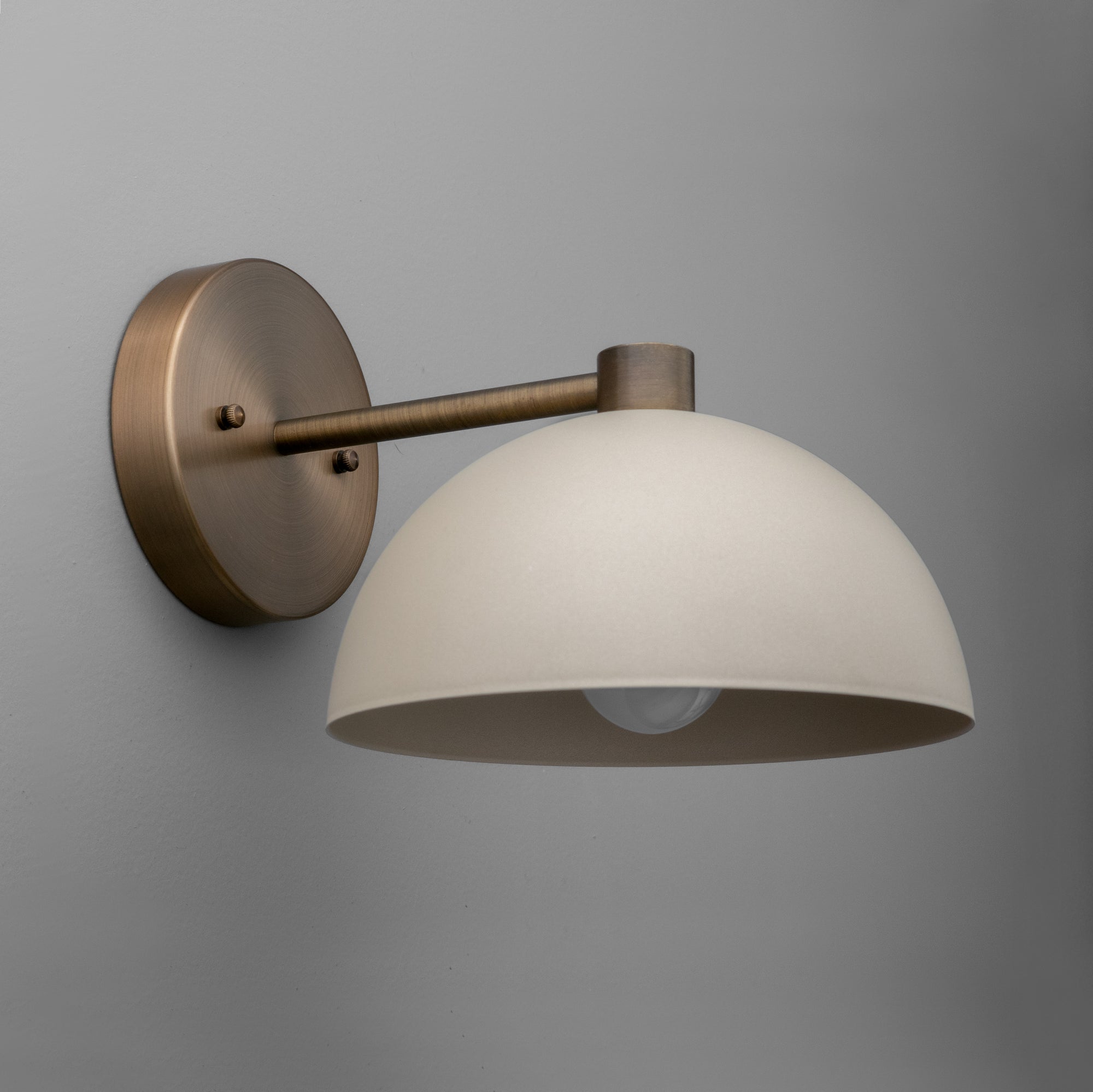 Wall sconce with matte cream dome shade and antique brass finish mount and arm. - SCONCE MODEL NO. 2946