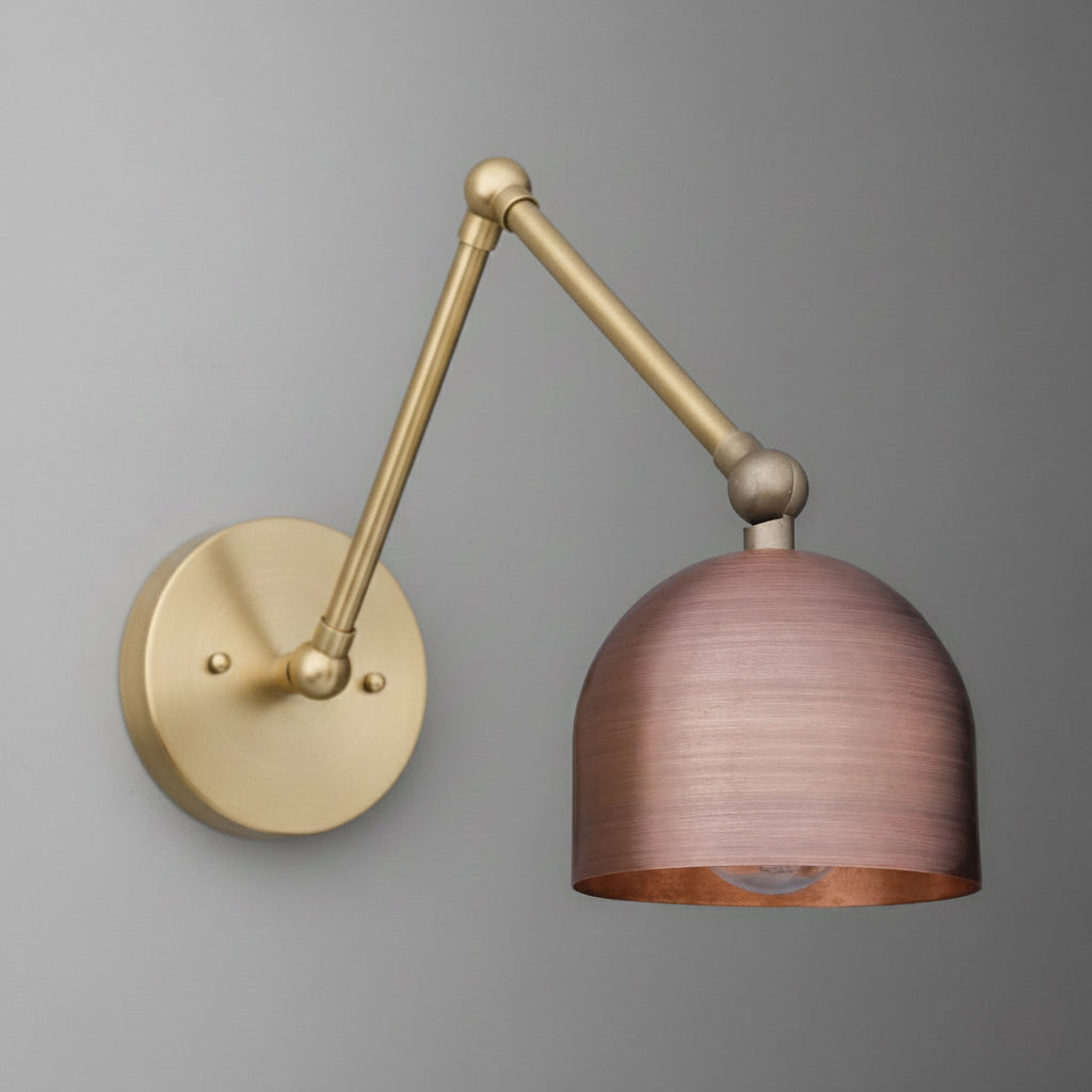 Adjustable wall sconce with a round brass base and an articulated arm holding a copper dome-shaped shade. - SCONCE MODEL NO. 5997