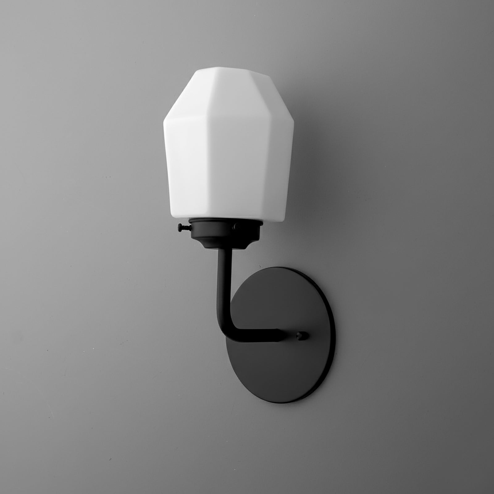 Matte black metal wall sconce with a geometric white glass shade and single bulb design. - SCONCE MODEL NO. 1062