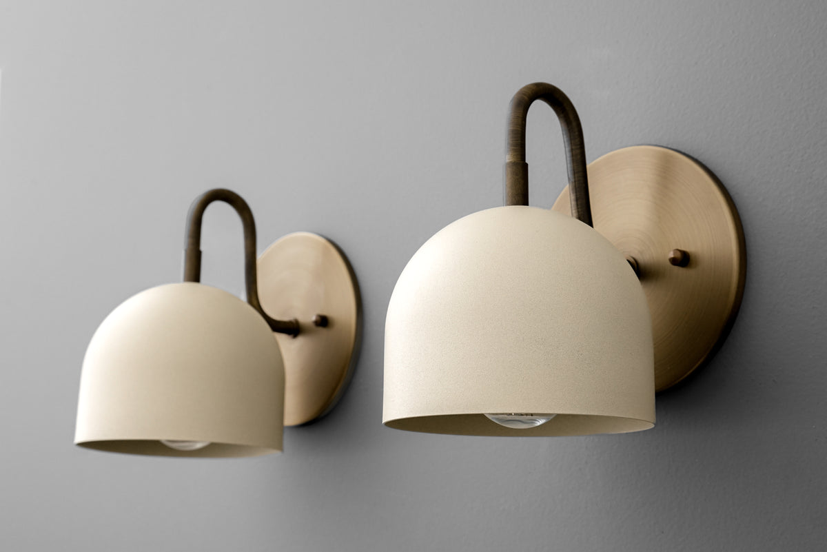 Antique brass wall sconce with curved arm and smooth cream dome-shaped shade. - Sconce Model No. 5416