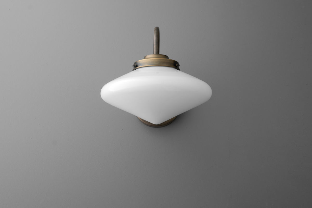 Wall-mounted sconce with white frosted glass shade and brass finish fixture. - SCONCE MODEL NO. 1021
