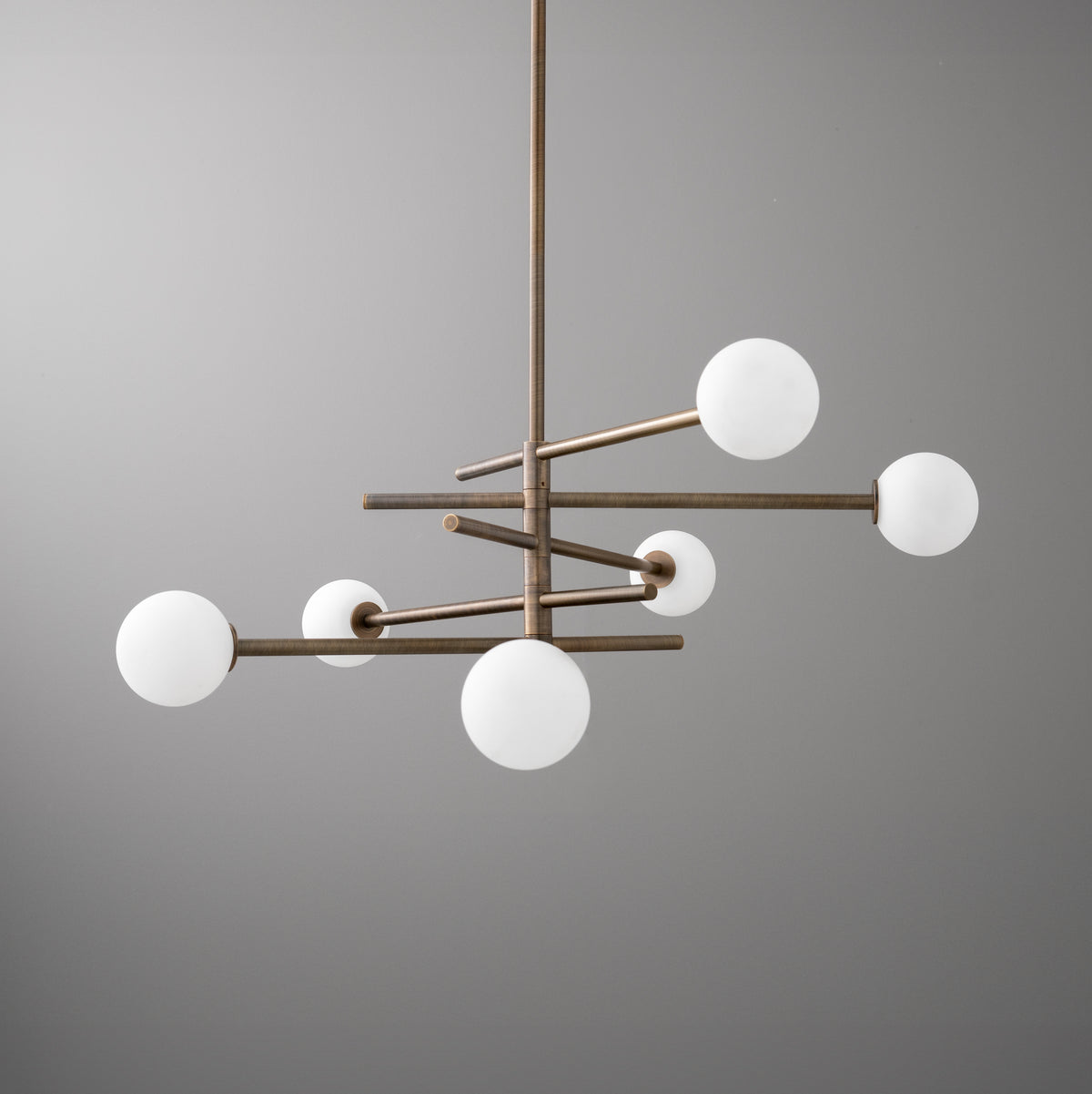 Minimalist chandelier with six frosted white globe lights and antique brass finish. - CHANDELIER MODEL NO. 8576